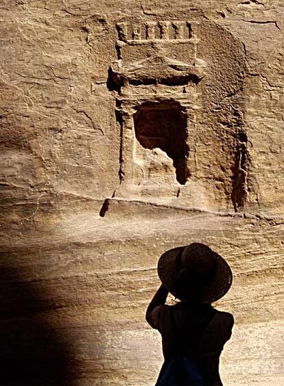 Una mujer fotografa una hornacina en el desfiladero de Siq, que conduce a la ciudad de Petra.