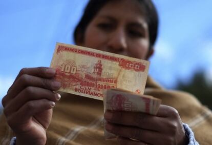 Rufina Condori, de 34 años, controla su dinero después de haber recibido su sueldo en La Paz (Bolivia). Con sus dos trabajos, llega a ganar el salario mínimo, alrededor de 130 euros mensuales.