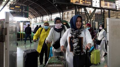 Un grupo de turistas asiticos llegan protegidos con mascarillas a la estacin del Norte de Valncia, este jueves.