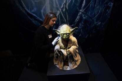 Una trabajadora ayuda a desempaquetar el títere de Yoda utilizado en las películas originales para una exposición sobre las identidades de Star Wars en Londres (Inglaterra). 