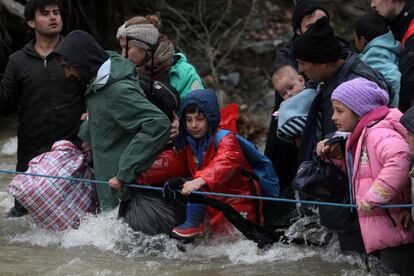 Varios refugiados cruzan un r&iacute;o en su camino a Macedonia, el 14 de marzo de 2016.
 