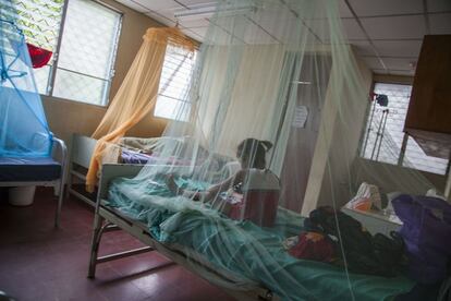 Una niña bajo una mosquitera en la sala del centro de salud preparada para luchar contra el virus.