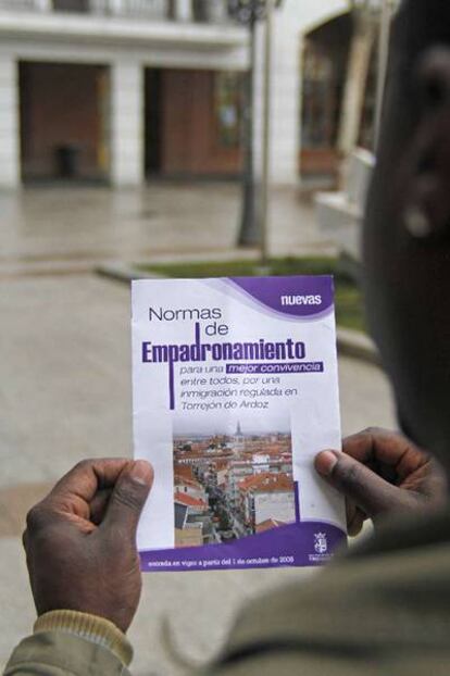 Simón, de Guinea Ecuatorial, muestra el folleto con las normas de empadronamiento de Torrejón.