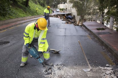 Un operario del ayuntamiento de Málaga trabaja en la calle Flamencos tras producirse un socavón por las fuertes lluvias.