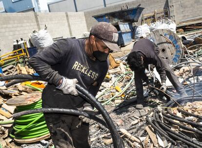 Dos trabajadores separando los cables de cobre para pelarlos, en la empresa Álvarez San Miguel.
