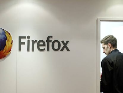 Un hombre junto a un logo de Firefox.