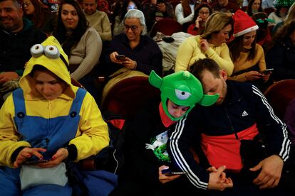 People in costumes wait before the start of the draw of Spain's traditional Christmas Lottery "El Gordo" at Teatro Real, in Madrid.