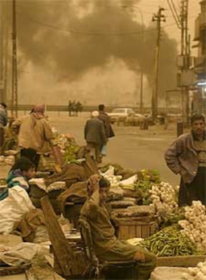 Vendedores callejeros de frutas y verduras, ayer, en Bagdad, ciudad que sufría una intensa tormenta de arena.