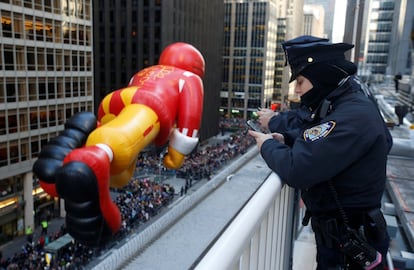 Policías de Nueva York ven el desfile de Acción de Gracias desde lo alto de un edificio en la Sexta Avenida. 