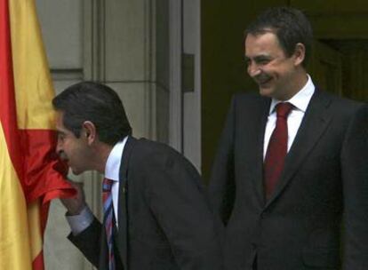 Miguel Ángel Revilla besa la bandera española ante José Luis Rodríguez Zapatero a la entrada de La Moncloa.