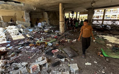 Los palestinos observan los daños producidos por el bombardeo en el interior de la escuela.