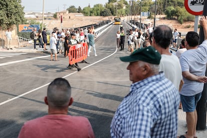 Vecinos y algunas autoridades observan los primeros vehículos que cruzan el puente. 
