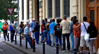 Los usuarios del comedor de Casa Caridad en Valencia, este martes, esperan para entrar a comer.