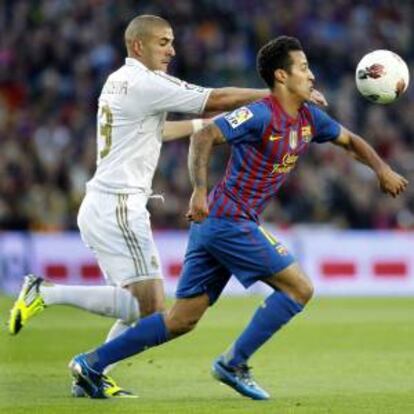 En la imagen, el centrocampista del FC Barcelona Thiago Alcántara (d), pelea un balón con el delantero francés del Real Madrid Karim Benzema, durante el un partido de la jornada de Liga en Primera División disputado esta noche en el Nou Camp de Barcelona. EFE/Archivo