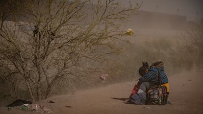 Una migrante se resguarda del polvo en la frontera de Ciudad Juárez (México) con Texas (Estados Unidos), el 30 de marzo