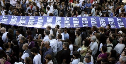 Integrantes del colectivo Madres de Plaza de Mayo llevan una pancarta con retratos de víctimas de la dictadura militar, durante una marcha en Buenos Aires, el 24 de marzo de 2008.