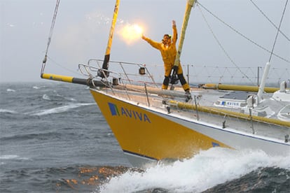 Dee Caffari agita sus brazos de alegría a bordo del <i>Aviva.</i>