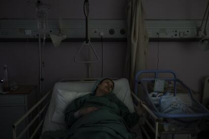Una mujer con su hijo recién nacido en una habitación oscura dentro de la unidad pediátrica del Hospital Universitario Rafik Hariri. Los propios pacientes apagan las bombillas de sus habitaciones para ahorrar suministro eléctrico; ellos también son conscientes de las dificultades.