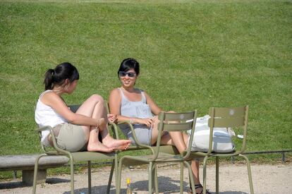 Dos mujeres disfrutan del día soleado en los jardines del parque de Luxemburgo en París.