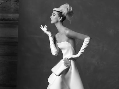 Lisa Fonssagrives:
Considerada como la primera supermodelo de la historia, la sueca Lisa Bernstone (1911-1992) trabajó para las grandes publicaciones de moda –­Vogue, Life, Town & Country– entre 1930 y 1950. Se casó con dos fotógrafos –Fernand Fonssagrives (en 1935) e Irving Penn (1950)–, pero sedujo a través del objetivo a muchos otros con su estilo sofisticado, de Man Ray a Richard Avedon. Inspirada en ella, la modelo luce un vestido escotado estilo años cincuenta con falda asimétrica en neopreno blanco de Roberto Diz, tocado de Heritage y guantes largos de piel blanca de Reliquiae.
