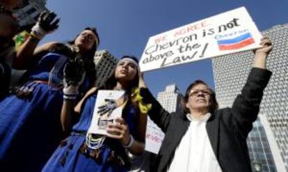 Varias personas ecuatorianas, algunas de ellas vestidas con indumentarias tradicionales, participan en una concentración para mostrar apoyo a la sentencia que acusa a la petrolera estadounidense Chevron de causar daños medioambientales. EFE/Archivo