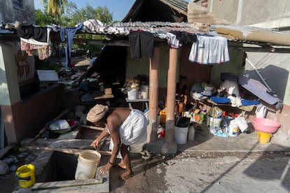 Una mujer saca agua de un pozo junto a su chabola en Los Cayos.