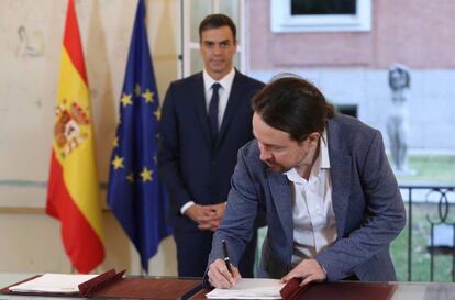 Iglesias firma el pacto en presencia de Sánchez, esta mañana en La Moncloa.