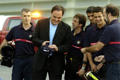 El director estadounidense Oliver Stone, posa junto a una dotación local de bomberos en San Sebastián momentos antes de presentar su película &#39;World Trade Center&#39;.