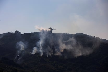 Un hidroavión descarga agua sobre uno de los focos del fuego en las proximidades de Verín, Ourense.