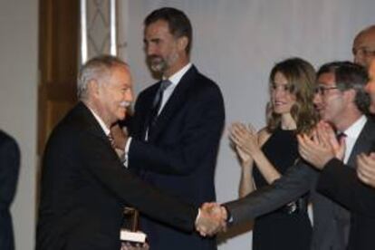 El escritor Eduardo Mendoza (i), felicitado en presencia de los príncipes de Asturias, tras recoger el premio al "Mejor autor iberoamericano", con motivo de la Feria Internacional del Libro "Liber 2013", que se celebra en Madrid.
