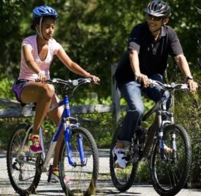 Obama pasea en bicicleta con su hija Sasha el verano pasado en Martha's Vineyard.