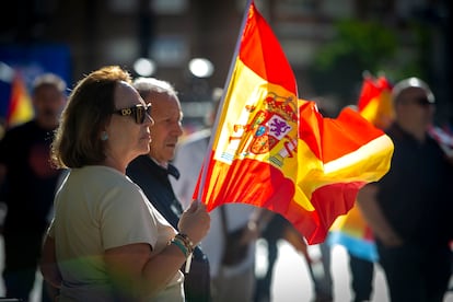 Una mujer sujeta una bandera de España, momentos antes del mitin convocado por el PP en Madrid. 