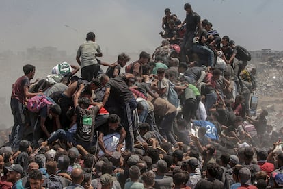 Decenas de palestinos saquean un camión con sacos de harina cerca de un punto de distribución en Zikim, norte de la Franja de Gaza, este domingo.