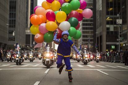 Un hombre disfrazado lleva globos durante el desfile por la Sexta Avenida de Nueva York.