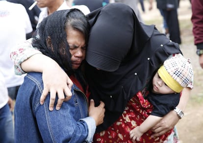 Dos familiares de las víctimas del accidente de autobús en Java lloran en un hospital de Tangerang Selatan, en Indonesia.