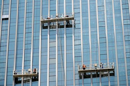 Trabajadores chinos limpian las ventanas de una reciente construcción en Qingdao, en el este de la provincia de Shandong .