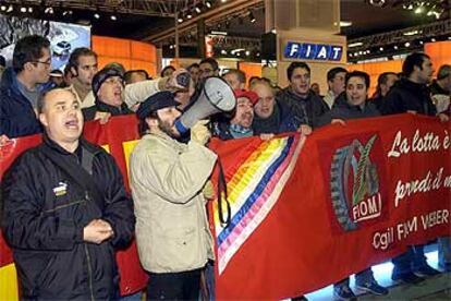 Un grupo de trabajadores protestan ante el <i>stand</i> de Fiat en una feria de Bolonia.