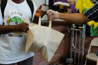 Marco Saavedra offers water and food to a migrant, who came to the restaurant in search of food