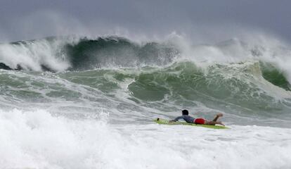 Mitchell Nugent rema con una tabla de surf hacia las intensas olas en Crystal Beach mientras la tormenta tropical Gordon azota el Golfo de México en Destub, Florida.