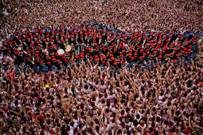 Revellers raise their arms as a band plays in the town hall square after the 'Chupinazo' rocket.