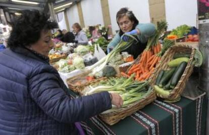 Coro despacha un puesto de frutas y verduras de San Sebastián.