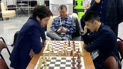 Teimour Radyábov y Jeffery Xiong analizan en el vestíbulo de la Academia de Ajedrez de Janti Mansiisk la partida que acaban de jugar en el escenario de la Copa del Mundo. En el centro, Wayne, padre de Jeffery