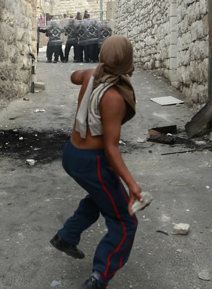 Un joven palestino lanza una piedra a un grupo de soldados israelíes en el barrio de Ras al-Amud, en Jerusalén Este.