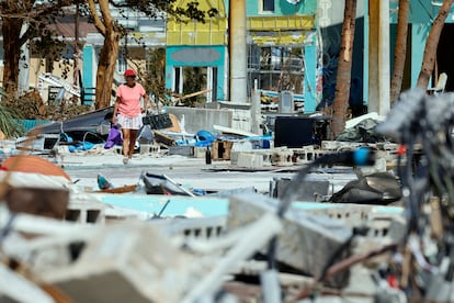 Una mujer camina por lo que queda de la zona de Times Square cerca del muelle Lynn Hall en la isla de Fort Myers Beach, este viernes.