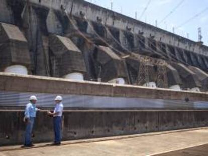 Fotografía del 12 de febrero de 2014 de dos trabajadores en la hidroeléctrica Itaipú, compartida por Brasil y Paraguay, que completó hoy, lunes 5 de mayo de 2014, 30 años de operación aún como la mayor generadora eléctrica del mundo pese a que China construyó una planta con mayor capacidad.