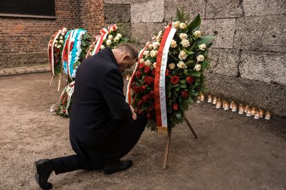 El presidente polaco, Andrzej Duda, se arrodilla frente al Muro de la Muerte en el antiguo campo de concentración nazi Auschwitz-Birkenau, durante una ceremonia en Oswiecim (Polonia), este lunes.