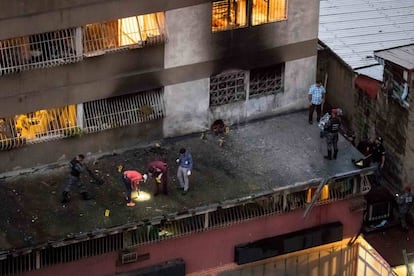 Agentes de policía recogen pruebas en un edificio cercano al suceso.