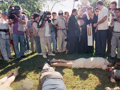 Un arzobispo y un grupo de periodistas junto a los cuerpos, en 1989.