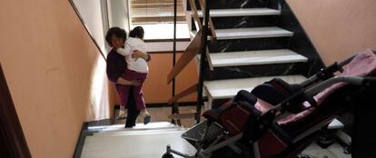 Pilar lleva en brazos a su hija Raquel en su piso de Tetuán.