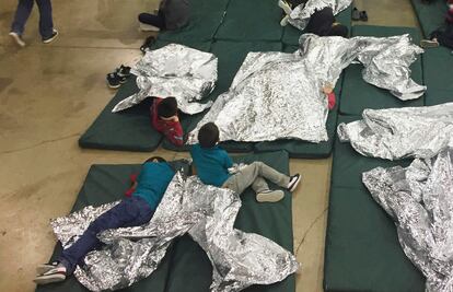 Niños migrantes separados de sus padres descansan en una jaula dentro de una instalación fronteriza en McAllen, Texas, en 2018.